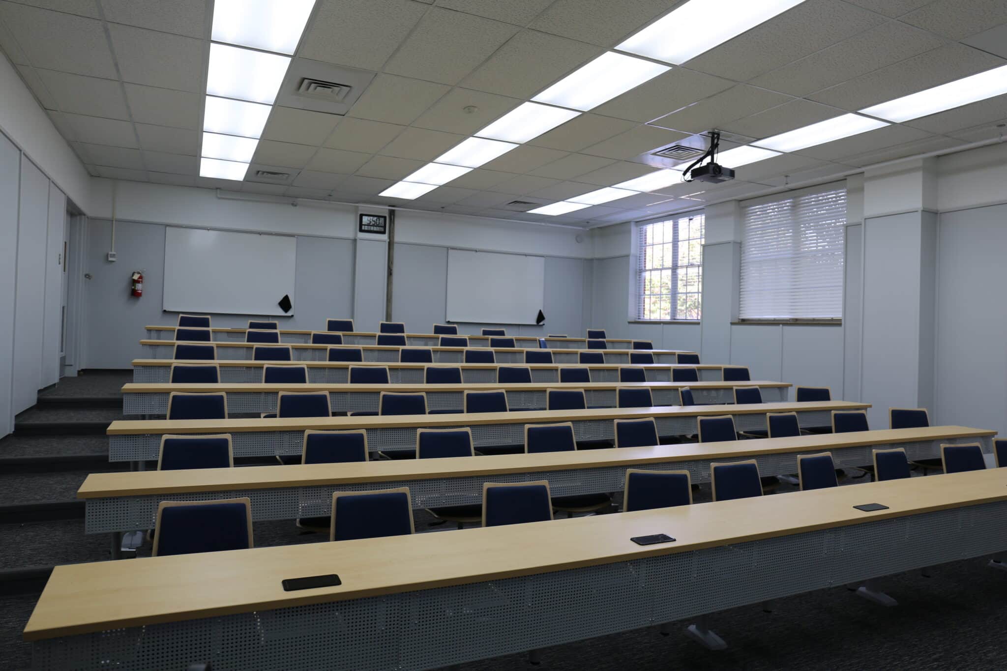 An empty lecture hall at Howard Payne University with tiered seating and desks, ready for a class session. | HPU