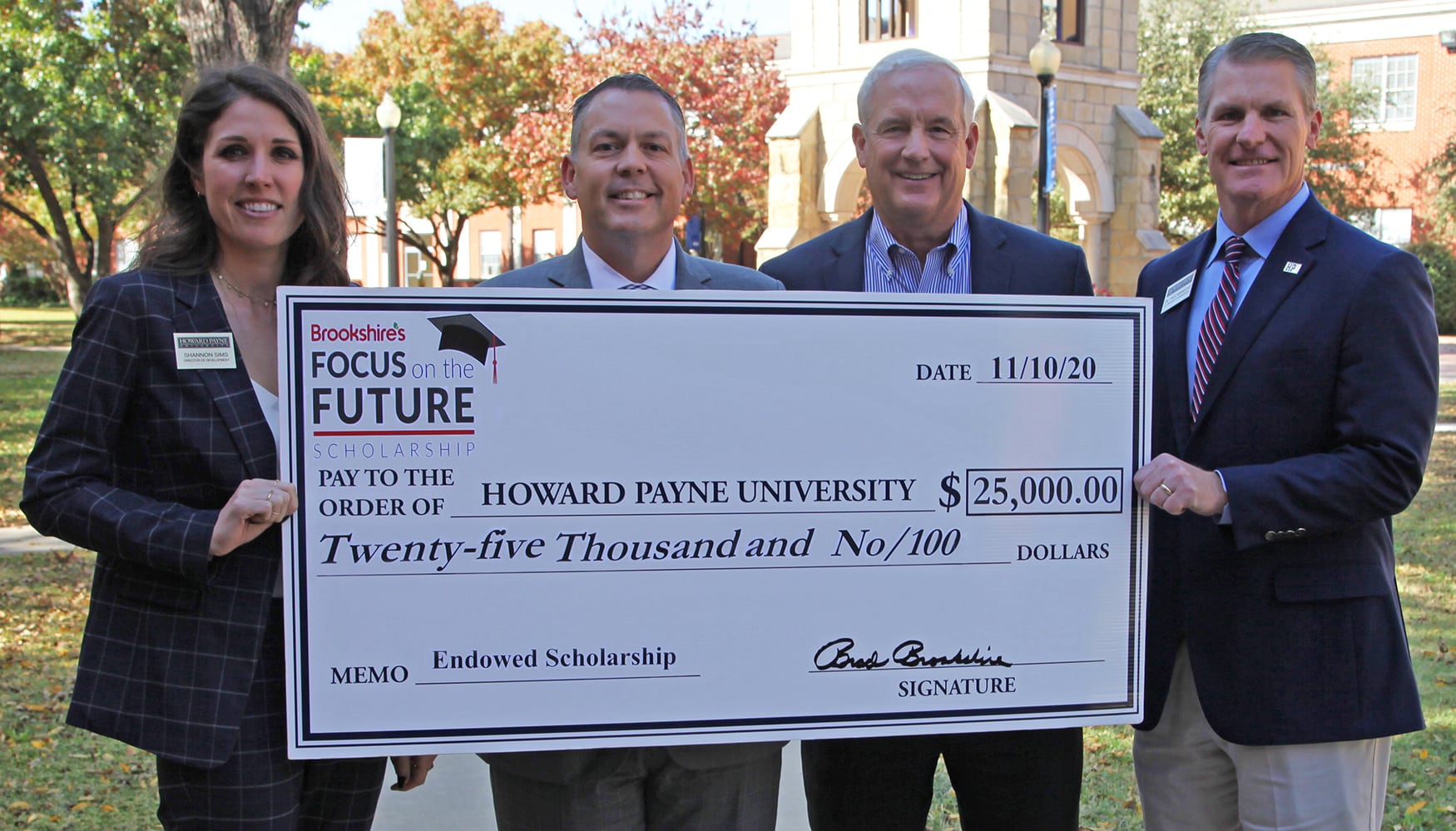 Four individuals posing with an oversized check for a $25,000 scholarship donation to Howard Payne University. | HPU