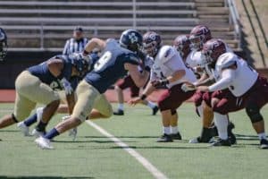 Howard Payne University football players poised at the line of scrimmage during a game. | HPU