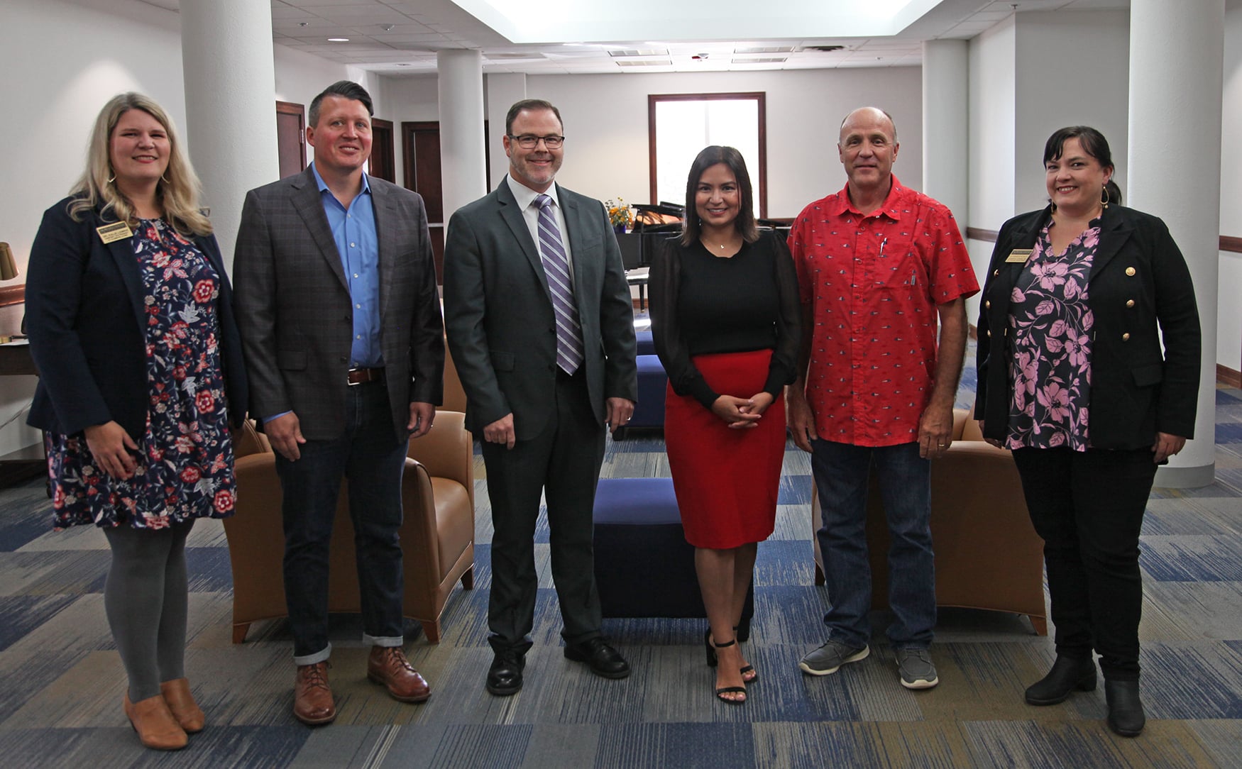 Group of six professionals from Howard Payne University standing in a line for a photo in an office setting. | HPU
