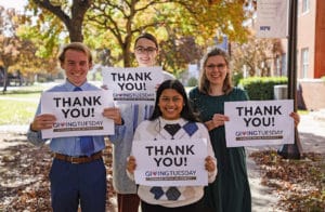 A group of four Howard Payne University students holding 'thank you' signs for Giving Tuesday event. | HPU
