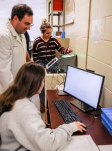 Doctor and students from Howard Payne University engaged in a laboratory experiment with a computer and equipment. | HPU