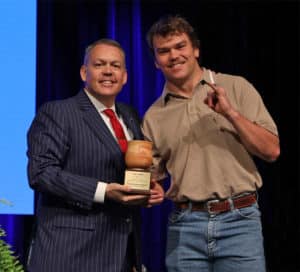 Two men smiling while one presents an award to the other at a Howard Payne University event. | HPU