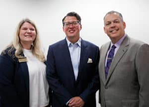 Three professionals from Howard Payne University are posing for a photo, with two men in suits and a woman in business attire. | HPU