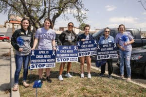 Group of Howard Payne University individuals holding signs promoting child abuse prevention month. | HPU