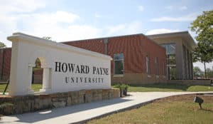 Entrance sign of Howard Payne University with a building in the background on a sunny day. | HPU