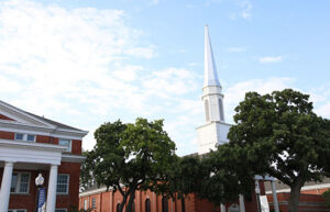 Classic Howard Payne University church architecture with a prominent steeple, set against a cloudy sky. | HPU