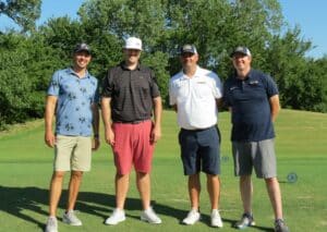 Four men smiling on a Howard Payne University golf course. | HPU