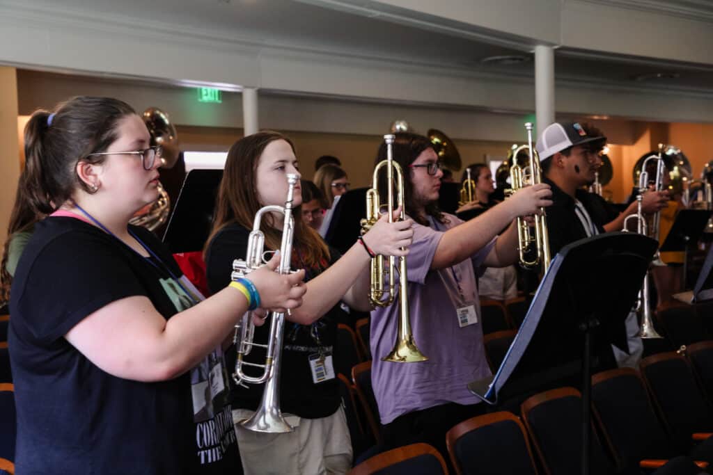 Horn players stand at attention during band rehearsal.