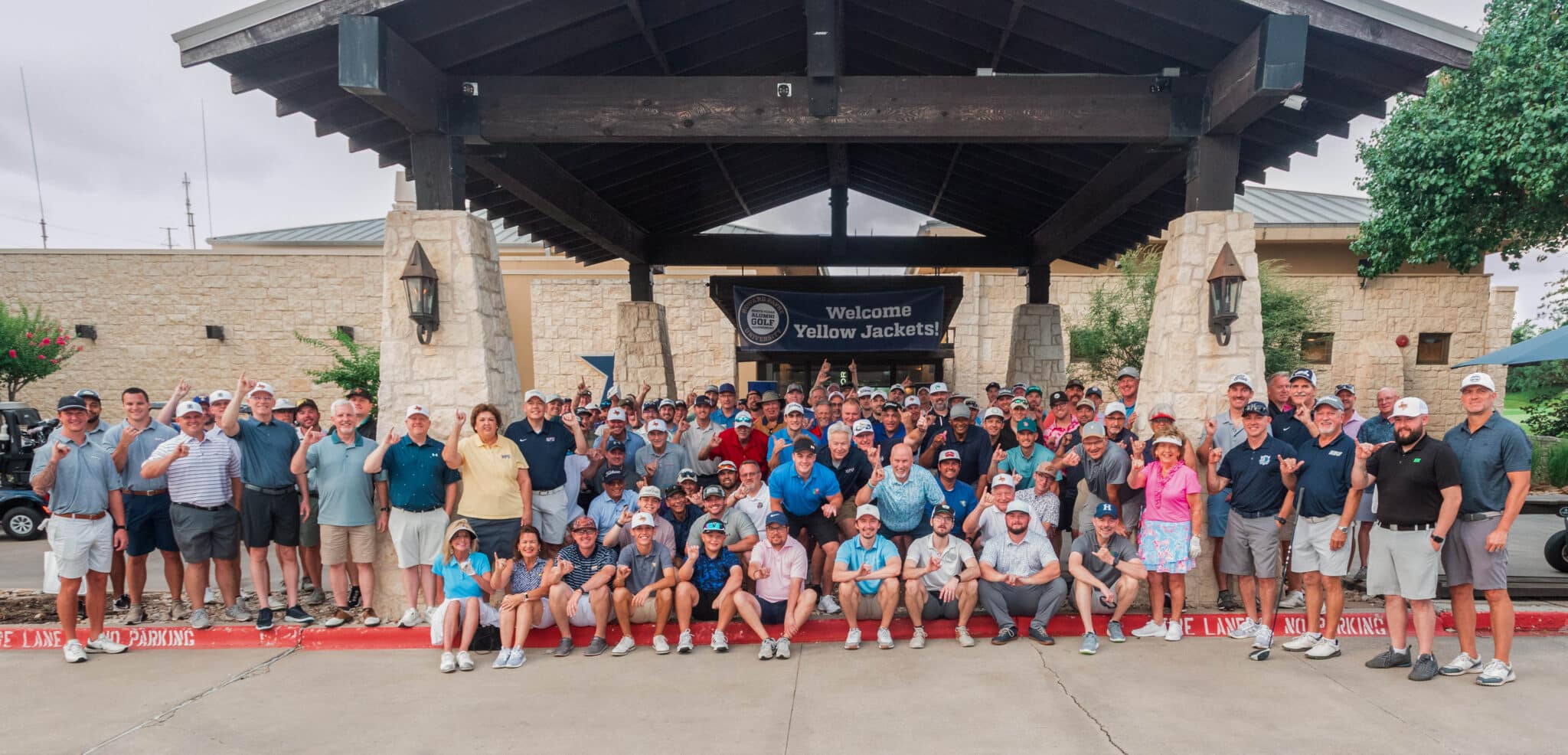 Attendees of HPU’s third annual North Texas Alumni Golf Tournament stand in front of Cowboys Golf Club in Grapevine.